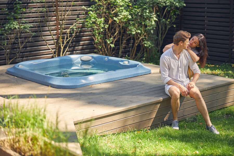 Couple relaxing beside an outdoor hot tub