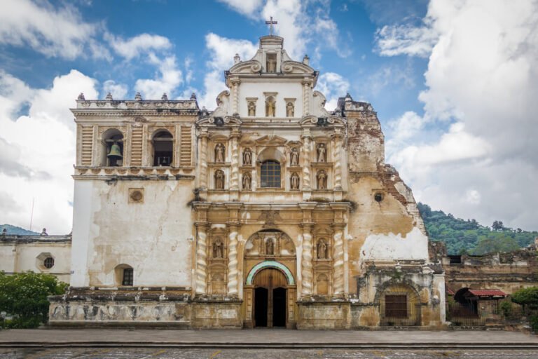 Iglesias en antigua guatemala - Historic colonial church facade in Antigua Guatemala under a bright blue sky.