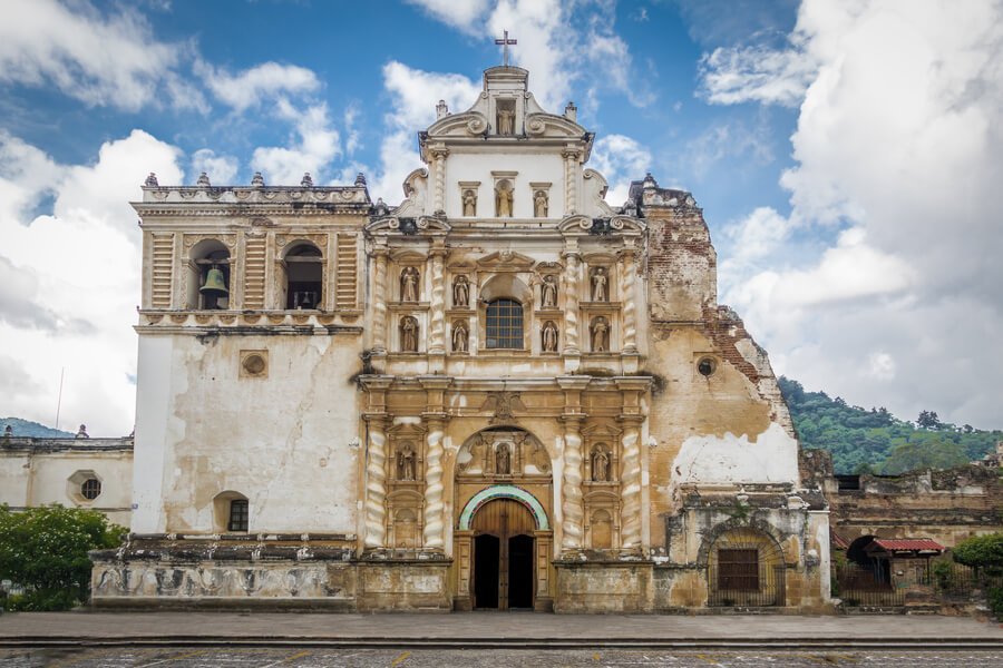 Iglesias en antigua guatemala - Historic colonial church facade in Antigua Guatemala under a bright blue sky.